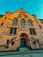Old architectural building in city against blue bright sky. Cityscape