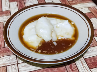 Bubur sumsum, traditional Indonesian food. Soft white marrow porridge served on a plate sprinkled...
