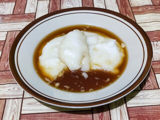Bubur sumsum, traditional Indonesian food. Soft white marrow porridge served on a plate sprinkled...