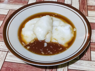 Bubur sumsum, traditional Indonesian food. Soft white marrow porridge served on a plate sprinkled...