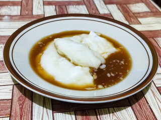 Bubur sumsum, traditional Indonesian food. Soft white marrow porridge served on a plate sprinkled...