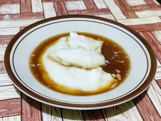 Bubur sumsum, traditional Indonesian food. Soft white marrow porridge served on a plate sprinkled...