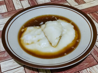 Bubur sumsum, traditional Indonesian food. Soft white marrow porridge served on a plate sprinkled...