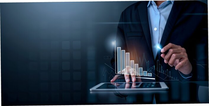 A businessman analyzes financial data on a tablet with a glowing digital graph - Powered by Adobe