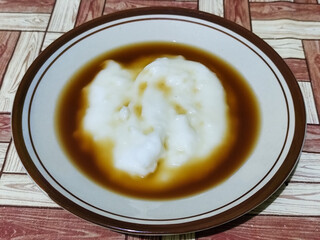 Bubur sumsum, traditional Indonesian food. Soft white marrow porridge served on a plate sprinkled...