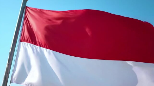 Indonesian Flag Waving Against Clear Blue Sky