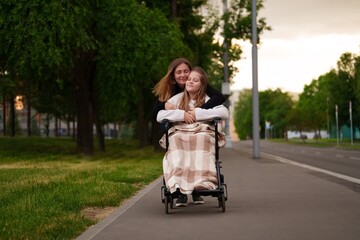 Mother and daughter with disability in wheelchair enjoy warm evening, joy flows through smiles and...