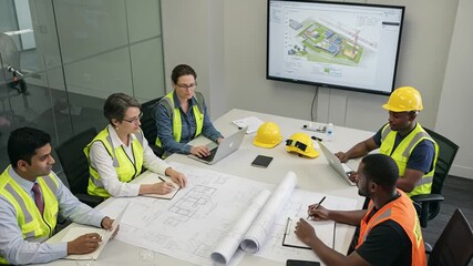 Team Meeting on Construction Plans with Digital Display