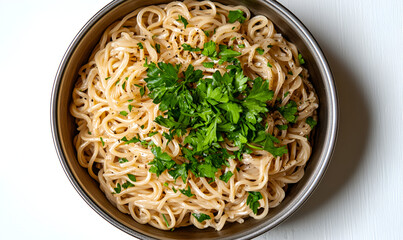 Overhead view of a pan filled with creamy spaghetti, garnished with fresh, vibrant green parsley on a white surface.