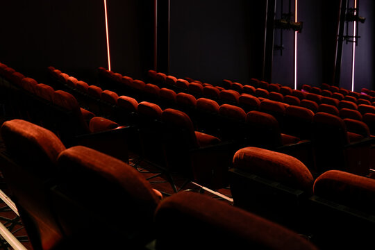 Empty Movie Theater With Rows of Cushioned Red Seats