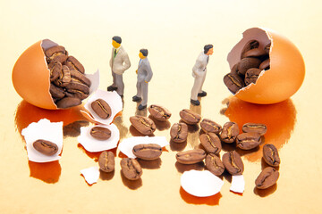 Tiny figures, some in suits, explore a fantastical scene of cracked orange eggs revealing coffee beans on a reflective golden stage, perfect for themes of imagination and discovery.