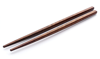 A pair of dark brown wooden chopsticks lies diagonally across a white surface, casting a soft shadow.