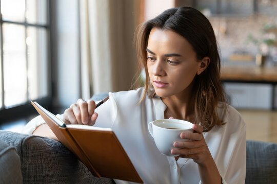 Woman relaxes at home with coffee and journal, enjoying a peaceful morning routine