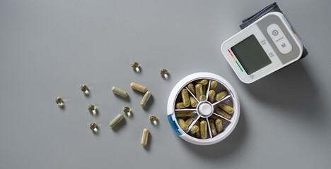 Health monitoring with dietary supplements and blood pressure device on a minimalist gray surface