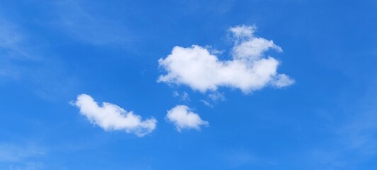 Soft white clouds with a beautiful blue sky in the morning light. Soft white clouds float in the clear blue sky. Clear blue sky, bright spring, soft sky gradient.