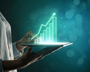 Person holding tablet displaying glowing green financial growth chart