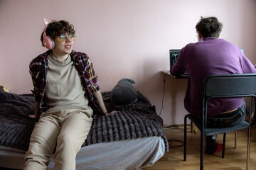Enjoying a cozy gaming afternoon with friends in a casual bedroom setting on a weekend