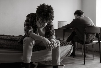 Reflections of solitude in a quiet room as two individuals navigate their own worlds