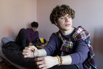 Young men relax and enjoy casual moments in a cozy room filled with warmth and friendship on a sunny afternoon