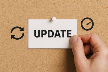 Update and progress symbolize information change with hand pinning a labeled sign on cork board