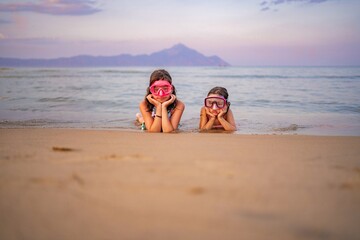 Sisters enjoying a magical evening at the beach with snorkeling gear