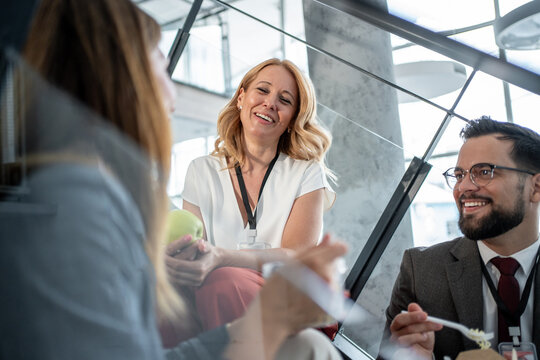 Businesspeople having lunch break on office stairs - Powered by Adobe