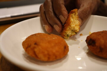 Partially Eaten South Indian Vadai Held in Hand – Crispy, Spiced Lentil Snack Enjoyed Fresh, Popular Breakfast and Tea-Time Street Food, Authentic Savory Appetizer Close-Up