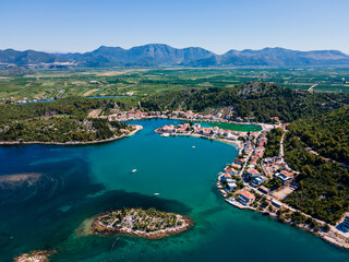 Aerial panorama of Blace village and Neretva River delta, showing coastline, green valley, and turquoise Adriatic Sea under clear summer sky