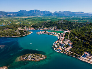 Aerial panorama of Blace village and Neretva River delta, showing coastline, green valley, and...