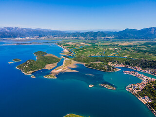 Obraz premium Aerial panorama of Blace village and Neretva River delta, showing coastline, green valley, and turquoise Adriatic Sea under clear summer sky