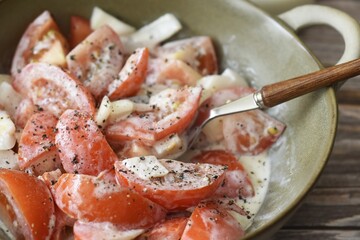 Tomato and onion salad with cream, salt and freshly ground pepper.