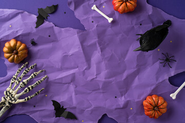 Creepy Halloween background featuring pumpkins, a skeleton hand, a bat, and festive decorations...