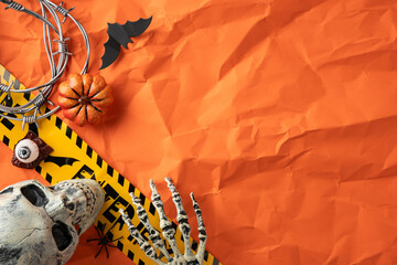 Halloween-themed props, including a skull, skeleton hand, and pumpkin on a festive backdrop