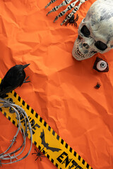 Spooky vertical Halloween-themed setup featuring a skull, barbed wire, and warning tape on orange