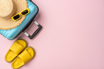 A stylish summer travel setup with a blue suitcase, straw hat, yellow slides, and sunglasses. Ideal...