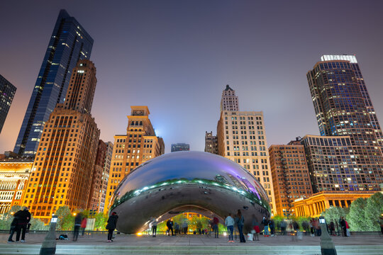 CHICAGO - ILLINOIS: MAY 12, 2018: Tourists visit Cloud Gate in Millennium Park in the evening.