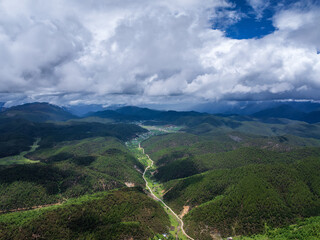 Naklejka premium Aerial view of forested valleys under clouds