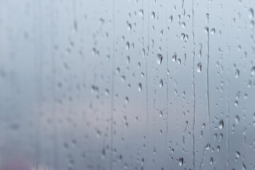 Background of raindrops running down on window with blurred, copy space