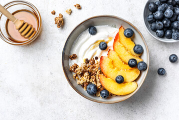 Granola bowl with greek yogurt, peach and blueberries