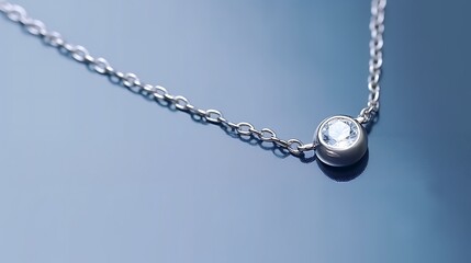 A light floating silver chain necklace with a solitaire diamond in bezel setting over a light slate blue background, minimal, sleek, and sharply rendered, full-frame image.