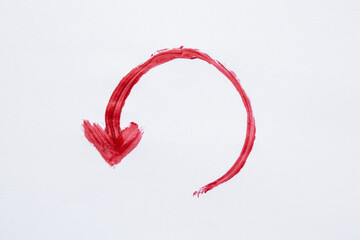 Red circular arrow painted with watercolor as a symbol of rotation, return, circular movement, decorative element on white