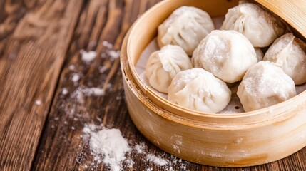 Fototapeta premium Steamed dumplings served in a bamboo basket on a wooden table dusted with flour.
