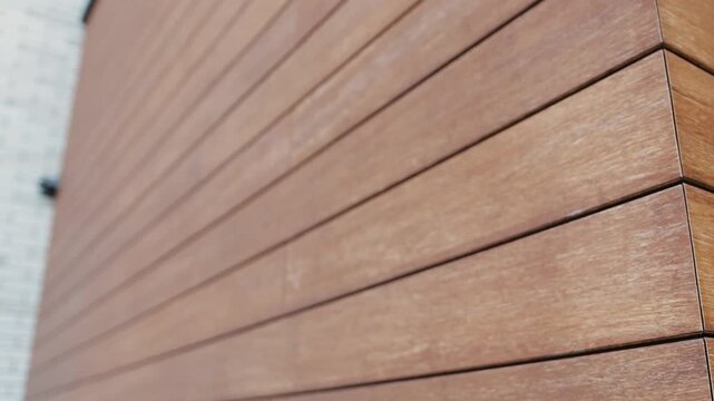 Exterior wall of the house close-up. Wood-look tiles. Elements of wooden wall cladding designed for modern buildings. Modern design.
