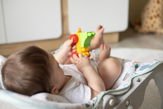 Adorable infant baby playing with kids toys at home