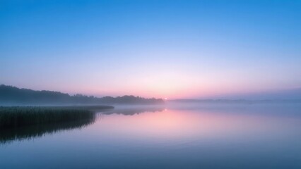 Fototapeta premium Calm Lake at Dawn with Misty Horizon