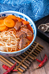 A bowl of traditional Chinese food braised beef noodles on a tray