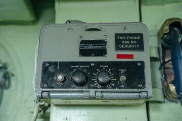 Close-up of a military phone device with a bold label stating This Phone Has No Security. The unit...