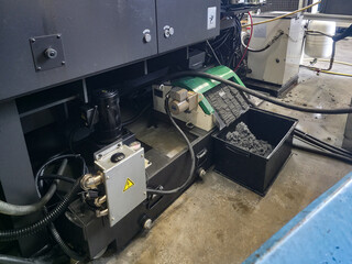 Industrial machinery operating in a workshop with various components and materials present while a maintenance activity takes place