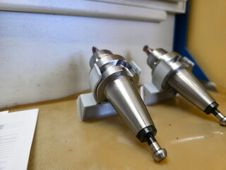Precision metal components displayed on a workbench in a manufacturing workshop during daylight hours