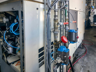 Industrial machinery with control valves and piping in a manufacturing facility during daylight